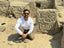 Luis Muro Ynoñán poses with a carving of a mythological bird-like creature. Ucupe Cultural Landscape Archaeological Project